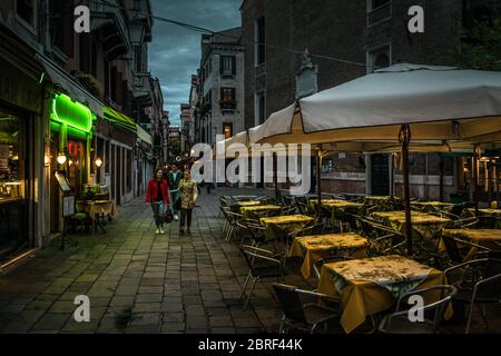Venedig, Italien – 20. Mai 2017: Nachts laufen die Leute auf der alten Straße. Blick auf die Stadt Venedig mit Café und Restaurants am Abend. Konzept des Reisens Stockfoto