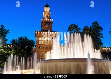 Sforza Schloss und schönen Brunnen in der Nacht, Mailand, Italien. Dieses Schloss wurde von Sforza, Herzog von Mailand, erbaut. Es ist ein berühmtes Wahrzeichen von Mailand. Alter Bogen Stockfoto