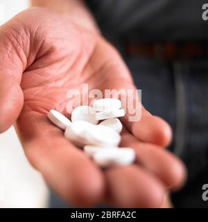 Männliche Hand hält weiße Medikation Tabletten Stockfoto