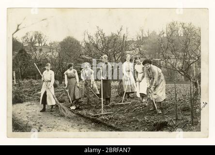 Britische Postkarte aus der Zeit des 1. Weltkriegs, 1900er von glücklichen Landarmee-Mädchen, Frauen, graben einen Plan, bereiten den Boden vor, um Gemüse oder Obststräucher zu Pflanzen, möglicherweise in einem Obstgarten oder Park, um den Kriegsanstrengungen zu helfen, 1900er Jahre graben nach Sieg, arbeiten an der Heimatfront, tun ihren Teil für Großbritannien. Großbritannien um 1916 Stockfoto