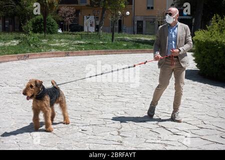 Campobasso, Molise Region, Italien: EIN Mann mit seinem Hund spazierengeht in einem Stadtpark während des Coronavirus Notfalls in Italien. Stockfoto