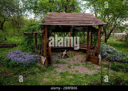 Holzlaube zwischen den Blumen im Garten. Stockfoto