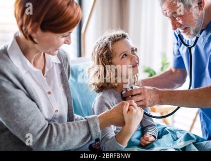 Arzt untersucht ein kleines Mädchen im Krankenhaus mit Mutter im Krankenhaus. Stockfoto