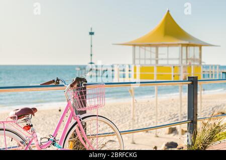 Rosa klassisches Fahrrad mit Korb am Brighton Beach an einem Tag in Südaustralien geparkt Stockfoto