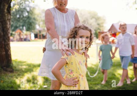 Kleine Kinder im Freien im Garten im Sommer, spielen.