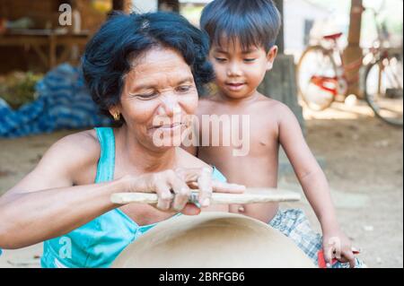 Eine Frau macht einen Tontopf, während ein kleiner Junge anschaut. Provinz Kampong Chhnang, Kambodscha, Südostasien Stockfoto