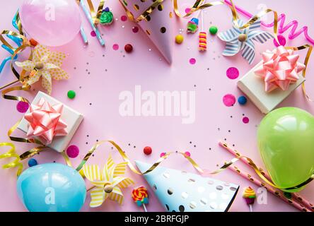 Clipboard und farbenfrohe Dekorationen auf pinkfarbenem Pastellhintergrund. Flache Lage, Draufsicht. Geburtstagshintergrund, Urlaubskonzept. Stockfoto