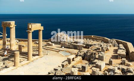 LINDOS, GRIECHENLAND - 04. OKTOBER 2018: Einige Touristen an der Akropolis von Lindos auf der griechischen Insel Rhodos. Stockfoto