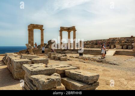 LINDOS, GRIECHENLAND - 04. OKTOBER 2018: Einige Touristen an der Akropolis von Lindos auf der griechischen Insel Rhodos. Stockfoto