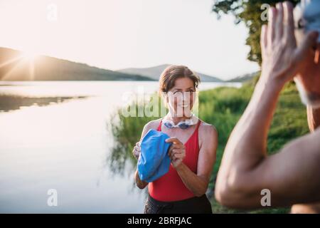 Seniorenpaar in Badeanzug vor dem Schwimmen am See im Freien stehen. Stockfoto