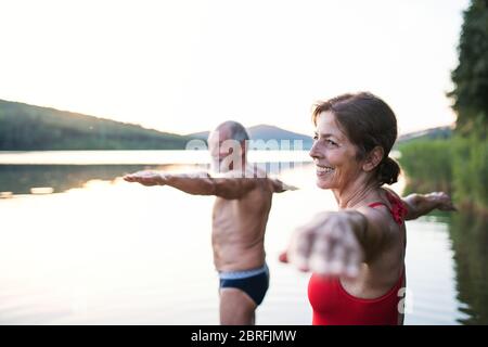 Ältere Paare in Badeanzug im See im Freien vor dem Schwimmen stehen. Stockfoto