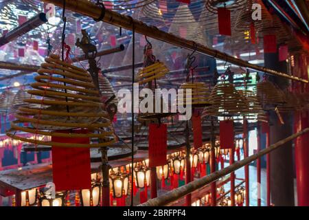 Weihrauchspulen hängen von der Decke, mit Gebeten auf roten Etiketten, die an ihnen angebracht sind, im man Mo Tempel, Hongkong, China, Asien Stockfoto