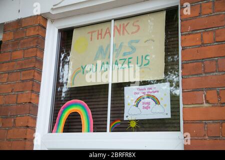 Gemälde von Regenbögen von Kindern in Fenstern von Häusern ausgestellt, um NHS-Gesundheitspersonal und Schlüsselarbeiter während der Covid-19 Coronavirus Pandemie danken Stockfoto