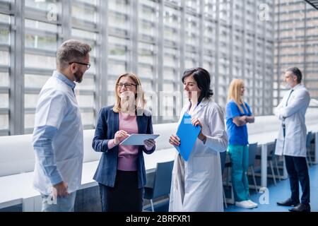 Gruppe von Ärzten im Gespräch mit einem pharmazeutischen Vertriebsmitarbeiter. Stockfoto