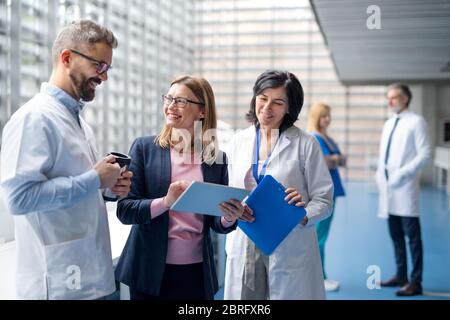 Gruppe von Ärzten im Gespräch mit einem pharmazeutischen Vertriebsmitarbeiter. Stockfoto