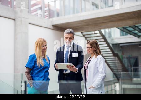 Gruppe von Ärzten im Gespräch mit einem pharmazeutischen Vertriebsmitarbeiter. Stockfoto