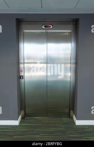 Moderner Aufzug mit geschlossenen Türen im zweiten Stock. Stockfoto