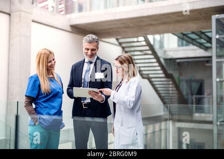 Gruppe von Ärzten im Gespräch mit einem pharmazeutischen Vertriebsmitarbeiter. Stockfoto