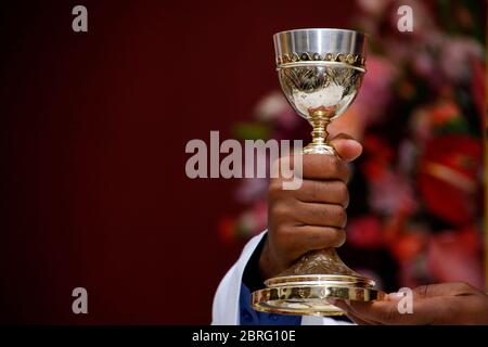 Heilige Wafer. Die heilige Kommunion in der Kirche. Die heilige Kommunion. Priester feiern Gottesdienst in der Kirche. Schale aus Glas mit Rotwein, Brot. Fest des Corpus C Stockfoto