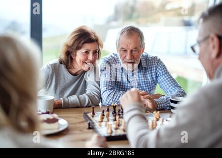 Gruppe von älteren Freunden zu Hause, Brettspiele spielen. Stockfoto