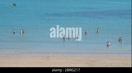 Lyme Regis, Dorset, Großbritannien. Mai 2020. UK Wetter: Einheimische und Familien genießen die heiße Nachmittagssonne im Badeort Lyme Regis. Obwohl die Parkplätze geschlossen blieben, war der Strand an diesem Nachmittag voller mit verantwortungsbewussten Strandbesuchern, die soziale Distanz aufrechterhalten, während sie die Sonne aufnässten. Kredit: Celia McMahon/Alamy Live News Stockfoto