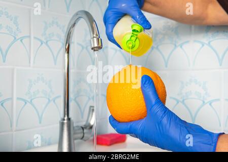 Zitrusfrüchte Sortiment Waschen in einem Leitungswasser. Leitungswasser spritzt auf Zitrusfrüchte. Früchte mit Seife von Keimen und Bakterien waschen. Stockfoto