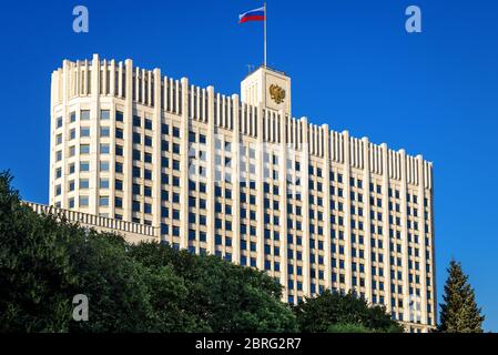 Haus der Regierung der Russischen Föderation (Weißes Haus) im Sommer, Moskau, Russland. Landschaftlich schöne Aussicht auf das Regierungsgebäude mit Wappen Stockfoto