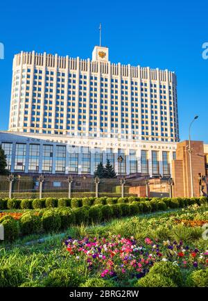 Das Haus der Regierung der Russischen Föderation (es ist auf der Fassade geschrieben), Moskau. Panoramablick auf das Weiße Haus und den Blumengarten im Zentrum von Moskau. Vertikal Stockfoto