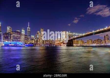 Eine lange Belichtung der Brooklyn Bridge und der Skyline von Manhattan bei Nacht, New York, USA Stockfoto