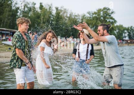 Gruppe von jungen Freunden beim Sommerfest, im See stehend. Stockfoto
