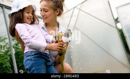 Schöne glückliche Mutter und Tochter, die auf dem Bauernhof, Garten Stockfoto