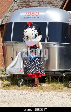 Sandleheath, Großbritannien. - 20. Mai 2020: Eine Betty Boop Vogelscheuche mit Gesichtsmaske. Das Hampshire Dorf Sandleheath veranstaltet einen jährlichen Charity Vogelscheuche Wettbewerb. Viele Einträge in diesem Jahr übernehmen ein Coronavirus Thema. Stockfoto