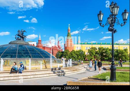 Moskau - 19. Mai 2019: Menschen gehen auf dem Manezhnaja-Platz im Moskauer Stadtzentrum, Russland. Glaskuppel mit Statue des Hl. Georg mit Blick auf den Moskauer Krem Stockfoto