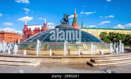 Moskau - 19. Mai 2019: Manezhnaja-Platz in Moskau, Russland. Moderne Glaskuppel mit Springbrunnen und St. George Statue mit Blick auf den Moskauer Kreml. Pano Stockfoto