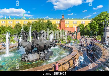 Moskau – 19. Mai 2019: Menschen gehen im Sommer auf dem Manezhnaja-Platz in Moskau, Russland. Panorama von schönen Garten und Brunnen mit Blick auf Moskau Kremli Stockfoto