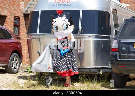 Sandleheath, Großbritannien. - 20. Mai 2020: Eine Betty Boop Vogelscheuche mit Gesichtsmaske. Das Hampshire Dorf Sandleheath veranstaltet einen jährlichen Charity Vogelscheuche Wettbewerb. Viele Einträge in diesem Jahr übernehmen ein Coronavirus Thema. Stockfoto