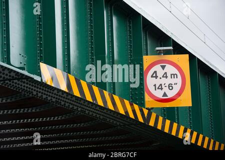 Höhenbegrenzungsschild auf einer Eisenbahnbrücke über einer Straße in Großbritannien. Stockfoto
