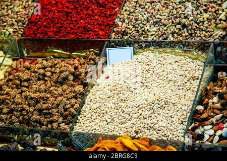 Die Fülle von Nüssen, Früchten, süßen Dingen in Kisten auf dem Markt von Barcelona. Stockfoto