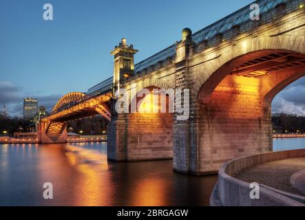 Puschkinski Brücke über Moskwa Fluss bei Nacht in Moskau, Russland. Schöne Aussicht auf die Moskauer Architektur mit Lichtern in der Dämmerung. Stockfoto