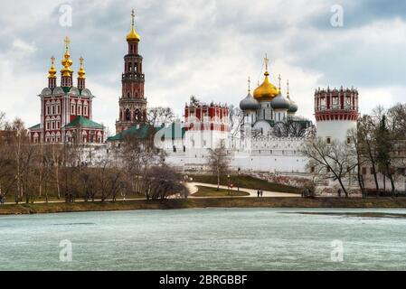 Nowodewitschy Kloster im Frühling, Moskau, Russland. Es ist eines der Wahrzeichen von Moskau. Blick auf das berühmte Kloster Novodevichy am eisigen Teich. Stockfoto