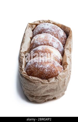 Frisch gebackene Donuts gefüllt mit Erdbeermarmelade in Papiertüte isoliert auf weiß Stockfoto