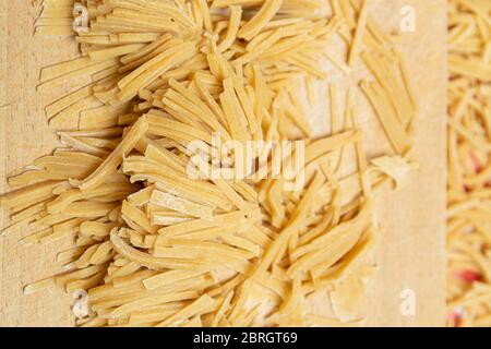 Hausgemachte Pasta aus gesundem Vollkornmehl auf einem Schneidebrett. Stockfoto