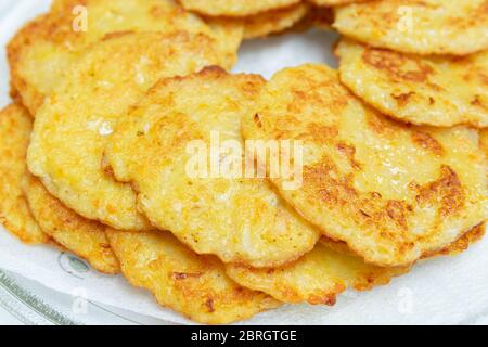 Hausgemachte Bratkartoffelpfannkuchen auf einem transparenten Teller. Stockfoto