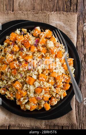 Frisch hausgemachten veganen Ofen gerösteten Kürbis, Blumenkohl und rote Zwiebel Salat oder Beilage auf Gusseisen Platte serviert, Gabel auf der Seite, fotografiert über Stockfoto