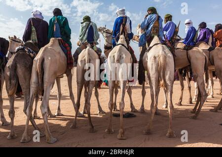 tuareg Menschen in traditionellen Kleidern sitzen auf Kamelen in der Wüste Stockfoto
