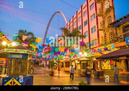 Santiago Arguello Fußgängerzone mit Geschäften und Bars mit Festival-Fahnen oben und tausendjährigen Bogen (el arco y reloj monumental). Tijuana, Mexiko Stockfoto
