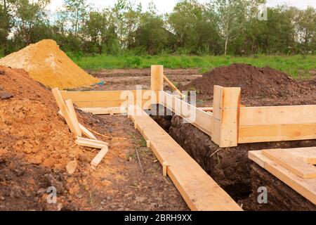 Holzschalung zur Erstellung von Streifenfundamenten für neue Hausbasis. Bau Haus von Anfang an Konzept Stockfoto