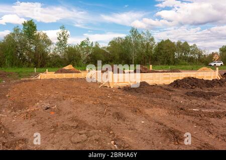 Holzschalung zur Erstellung von Streifenfundamenten für neue Hausbasis. Bau Haus von Anfang an Konzept Stockfoto