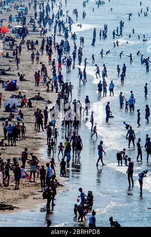 Strandbesucher entspannen und genießen die Sonne am Strand von Scheveningen am Himmelfahrtstag.warmes Wetter zog Menschenmassen an den Strand am Himmelfahrtstag trotz Empfehlungen, Abstand inmitten des Coronavirus-Ausbruchs zu halten. Stockfoto