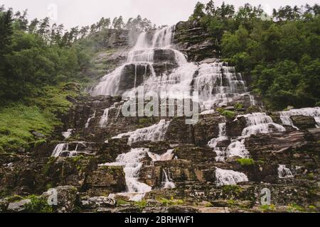 Blick auf den Tvindefossen oder Tvinnefossen Wasserfall bei Voss, Norwegen. Natur, Landschaft. Tvinde Camping. Zelt, Felsen Stockfoto